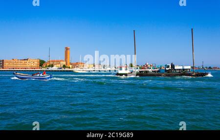 Versand eines LKW auf einem Lastkahn in venezianischer Lagune, Venedig Insel Waterfront mit Chiesa parrocchiale di Sant`Elena Imperatrice churcg, Italien Stockfoto